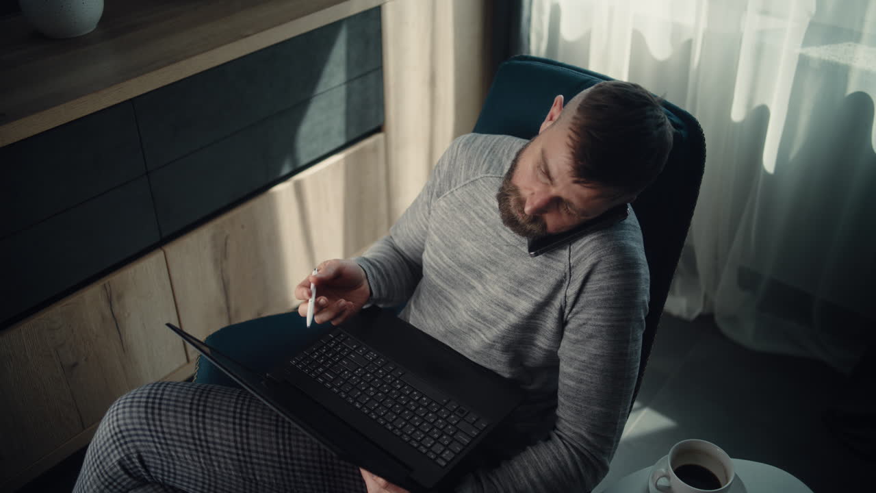 High Angle of Financial Analyst Having Phone Call, Working on Laptop, Monitoring Real-Time Stocks and Exchange Market Charts. Successful Businessman Works in Comfortable Office of Investment Bank.