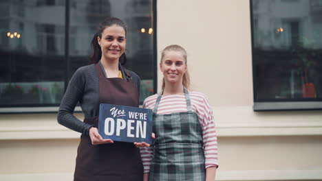 two women owners smiling at their new shop