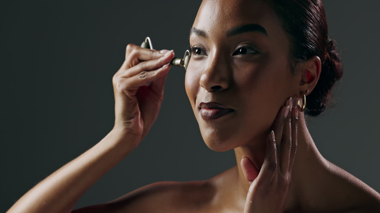 mujer aplicando un rodillo de jade en la cara
