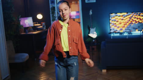 dutch angle shot of cute girl in neon lit apartment filming dance tutorial