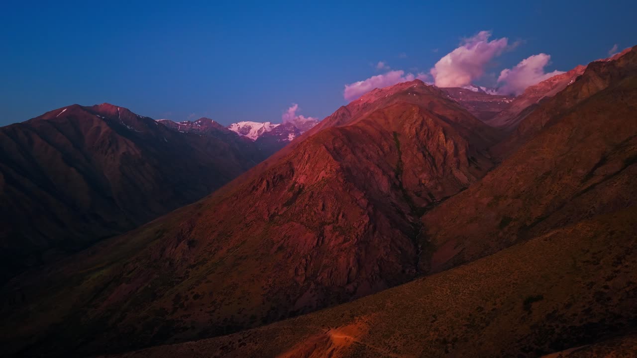 Nostalgic aerial view with orange mountains at sunset, solitude in the Andes Mountains, Yerba Loca park, Chile