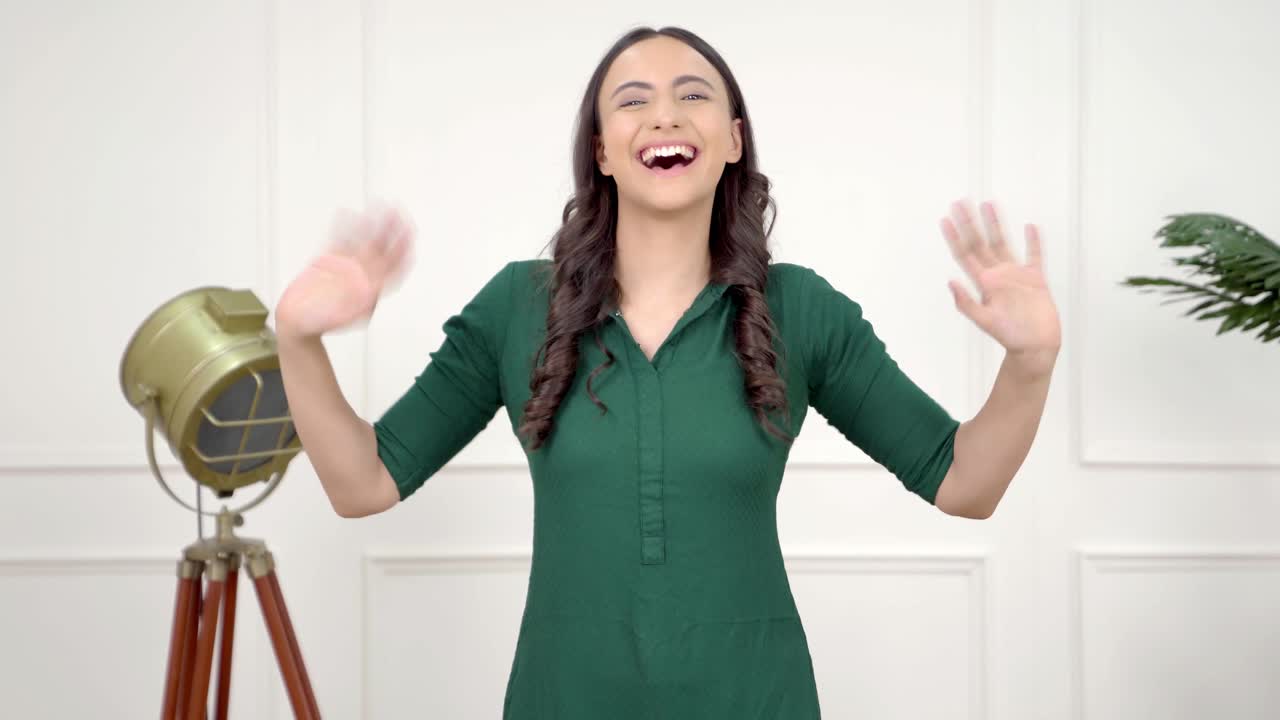 Donna indiana felice che saluta con la mano
