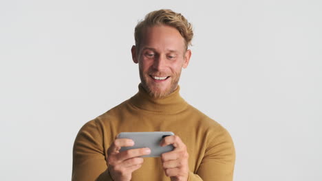 happy man playing videogame on phone