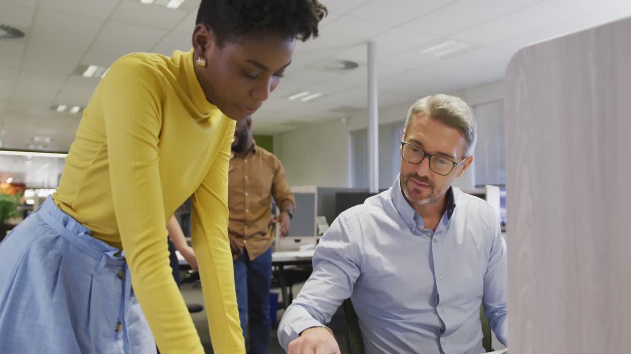 Diverse male and female business colleagues talking in office