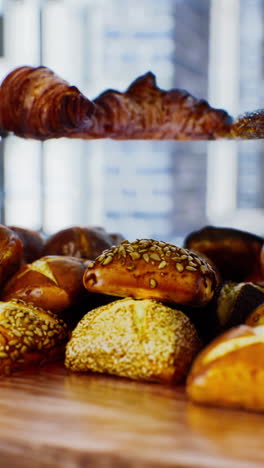 a variety of fresh baked breads and pastries on display at a bakery.