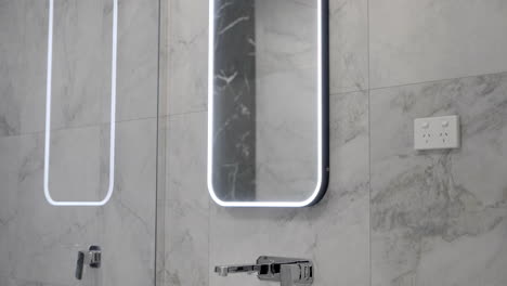 luxurious modern contemporary bathroom led mirror marble tiled wall white basin silver tap fixtures