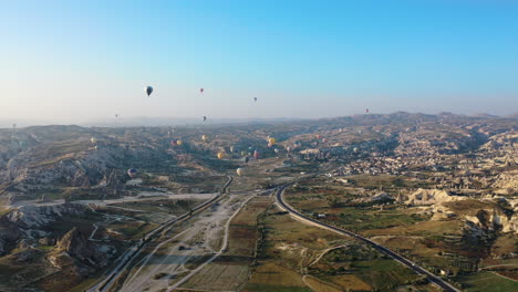 rotating epic cinematic drone shot above cappadocia looking up at the multiple hot air balloons in turkey