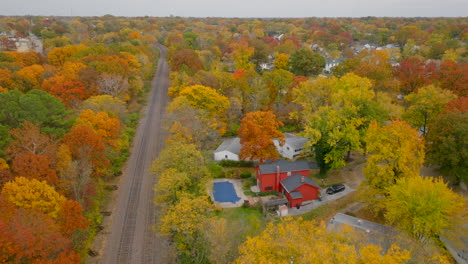 Antena-Sobre-Las-Vías-Del-Tren-A-Través-Del-Vecindario-En-Kirkwood,-Missouri-En-Otoño-En-El-Color-Máximo-Del-Otoño-En-Un-Hermoso-Día