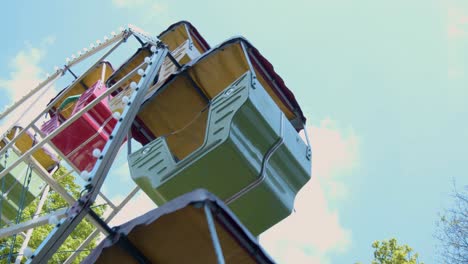 vintage carousel - ferris wheel turns in front of blue sky