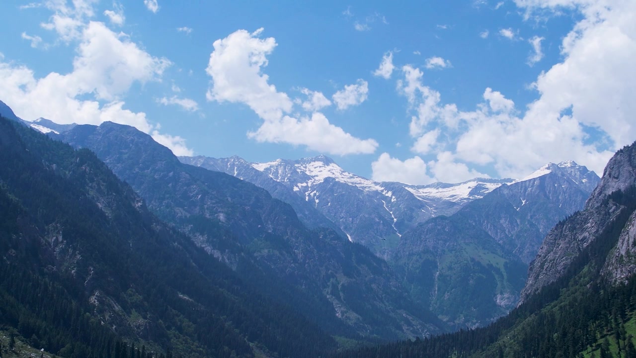 パキスタンのカイバル・パクトゥンクワ州に、漂う雲の下にそびえる雪を頂いたヒンドゥークシュ山脈。