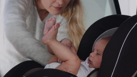 Madre-Joven-Poniendo-Al-Bebé-En-El-Asiento-Del-Automóvil-Asegurando-Al-Niño-Para-El-Viaje-Por-Carretera-Padre-Responsable-Que-Cuida-A-Los-Niños-Pequeños-La-Seguridad-En-El-Vehículo