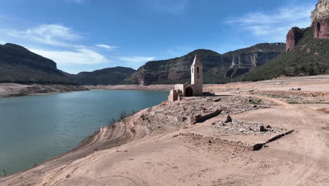 Antena-Del-Embalse-De-Sau,-Sequía-Severa,-Volar-Hacia-La-Iglesia-Histórica-Resurgida