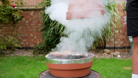 lifting off the homemade smoker to reveal the contents