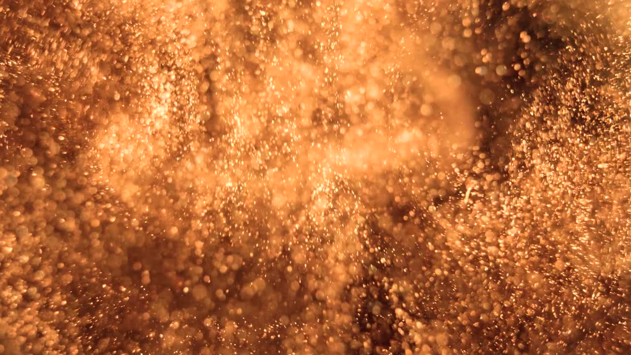 Elegant, detailed, and golden particles flow with shallow depth of field underwater