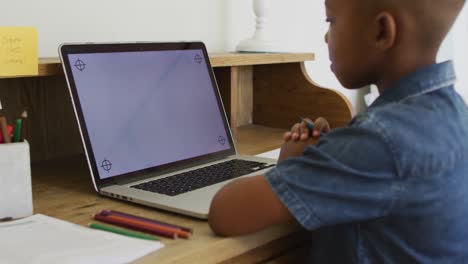 Niño-Afroamericano-En-Casa-En-Clase-Escolar-En-Línea,-Usando-Una-Computadora-Portátil-Con-Espacio-Para-Copiar-En-La-Pantalla