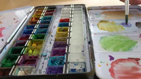 Pinsel,-Der-In-Lila-Aquarellfarbe-Getaucht-Und-Auf-Der-Malpalette-Gemischt-Wird