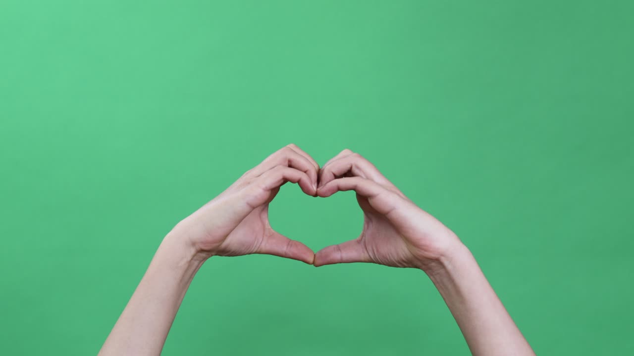 manos haciendo algunas figuras simbólicas en la llave de croma verde