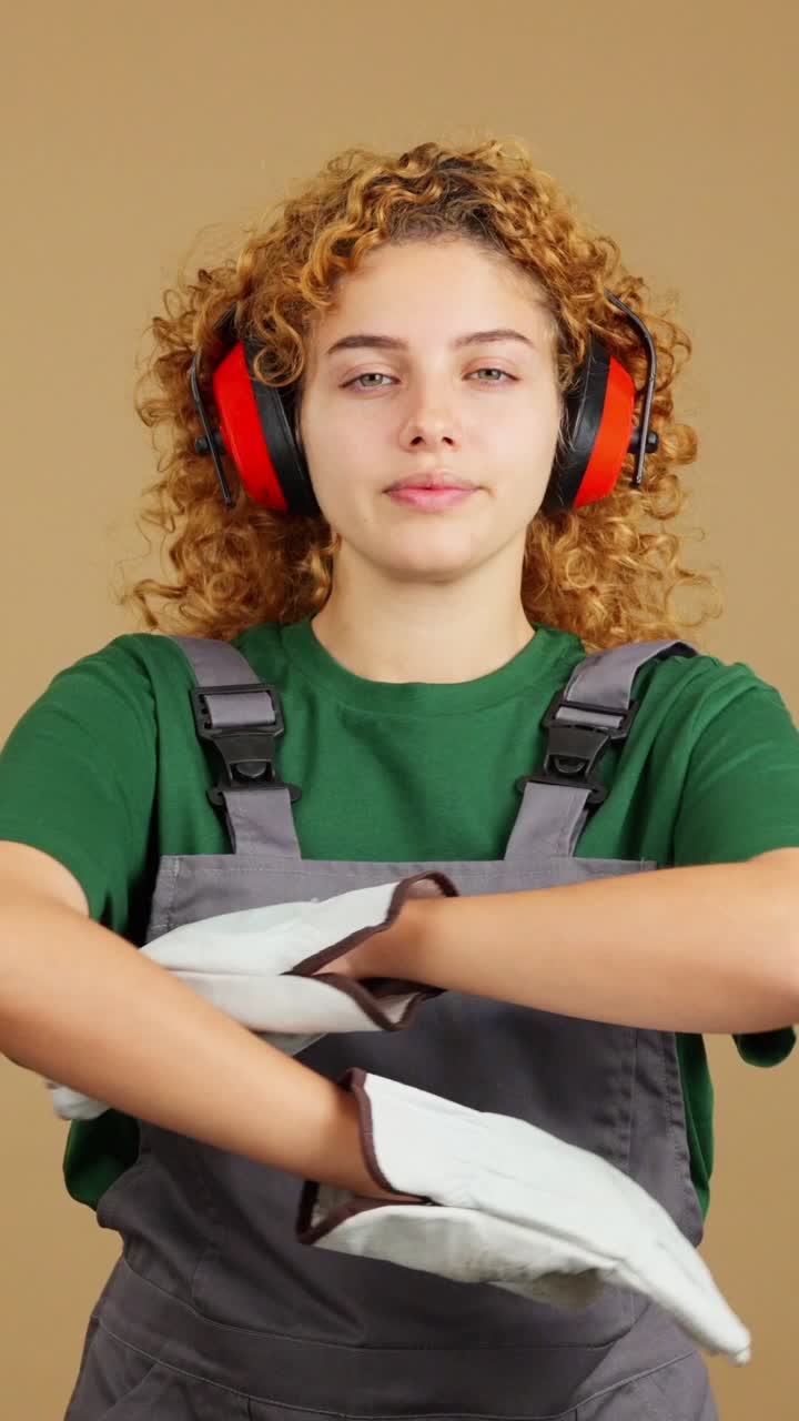 Portrait of a young woman in workwear and ear protection