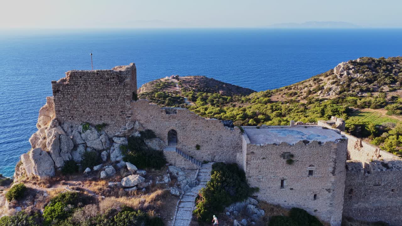 Aerial view of a castle ruins on a hill by the sea