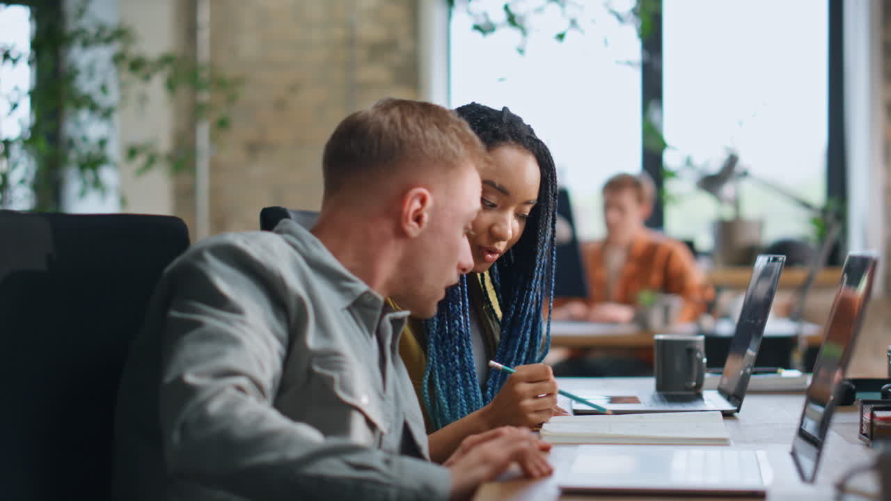 Office manager helping colleague doing work task sitting at workspace closeup.