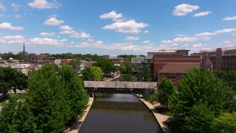 forward drone shot above dupage river in downtown naperville, illinois