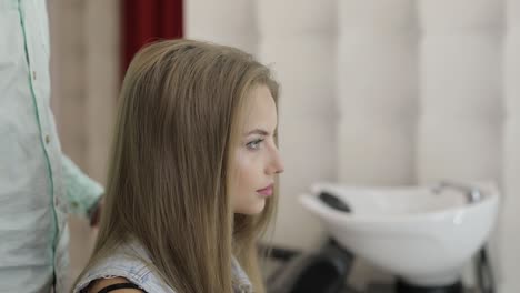 a woman getting her hair styled at a salon