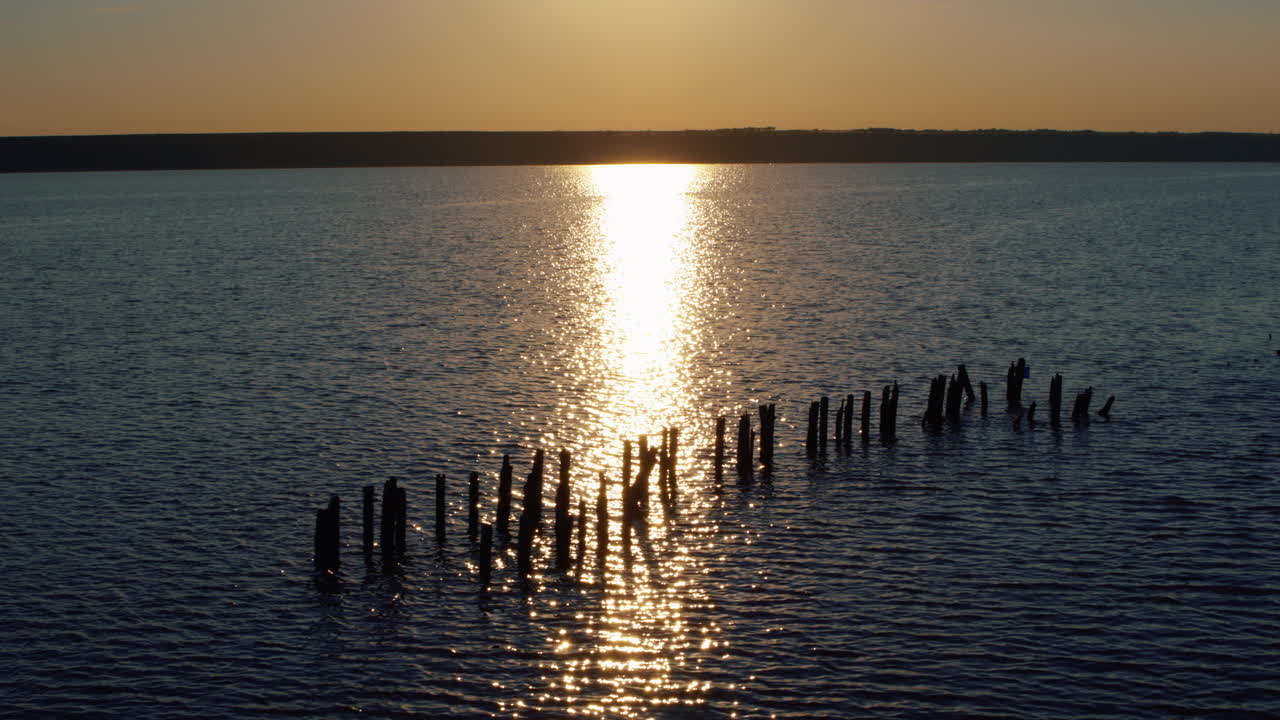 Vista de drone do reflexo do sol na costa marítima ao pôr do sol dourado. Luz solar romântica.