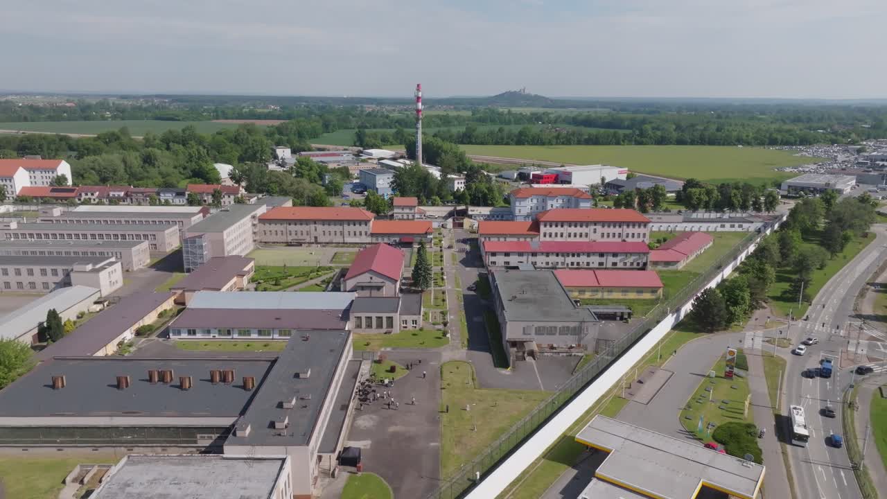 Aerial top-down (nadir) view of prison yards and cell blocks inside perimeter walls; steady overflight, continuous shot, daytime