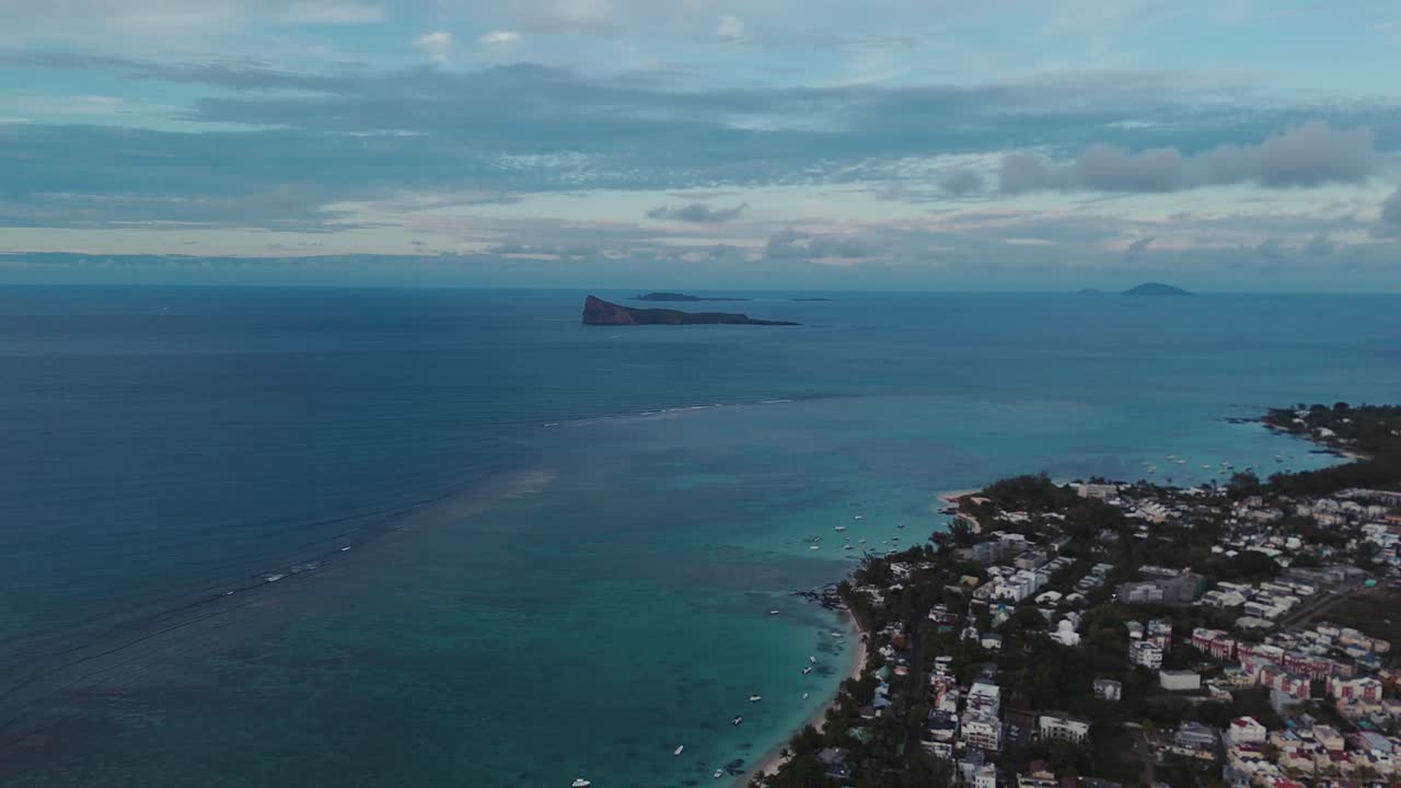 Filmato aereo di Pereybere Beach alle Mauritius, che mostra acque turchesi, un villaggio costiero e piccole isole all'orizzonte, catturando viaggi tropicali, stile di vita balneare e serenità dell'isola
