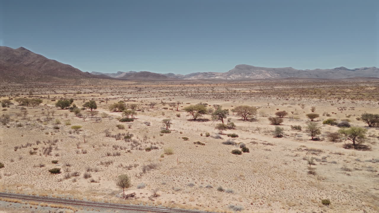 African Desert Landscape with Mountains and Railroad Tracks