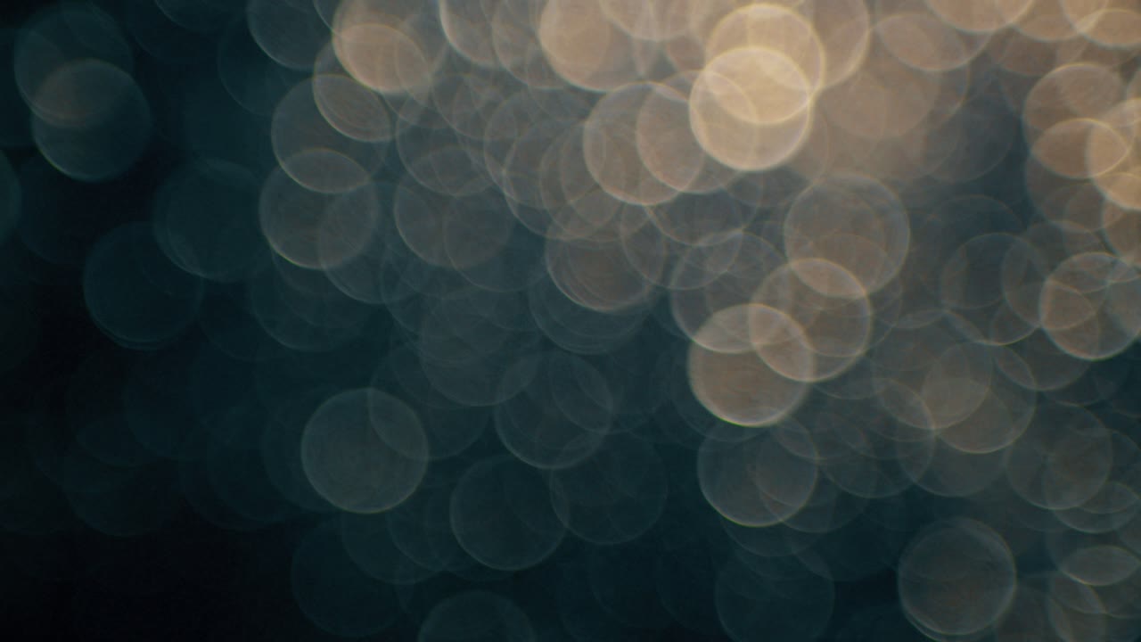 Abstrakte Bokeh-lys glitrende på mørk baggrund