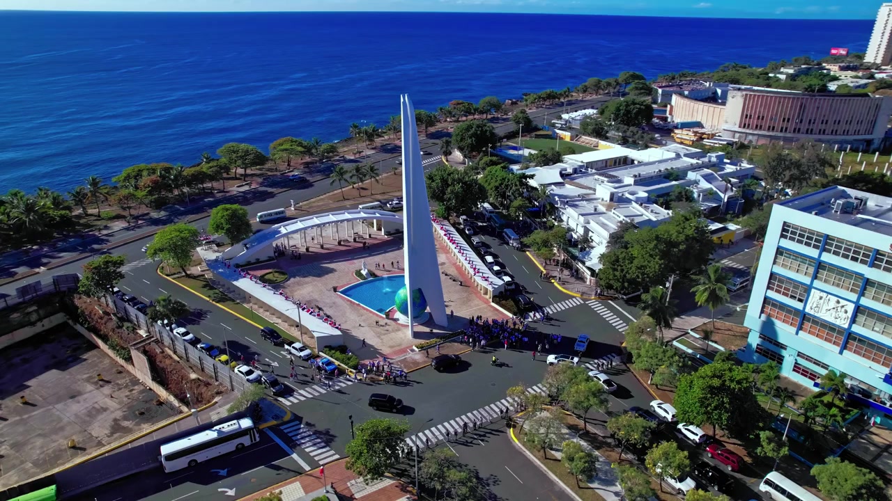 Daytime aerial drone shot orbiting 360 degrees around the Obelisco Hemisferico monument at Centro de los Heroes in Santo Domingo, Dominican Republic