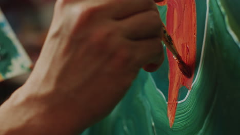 close-up of hand of artist painting on canvas with brush