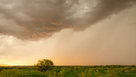 monsoon clouds and rain over landscape at sunset