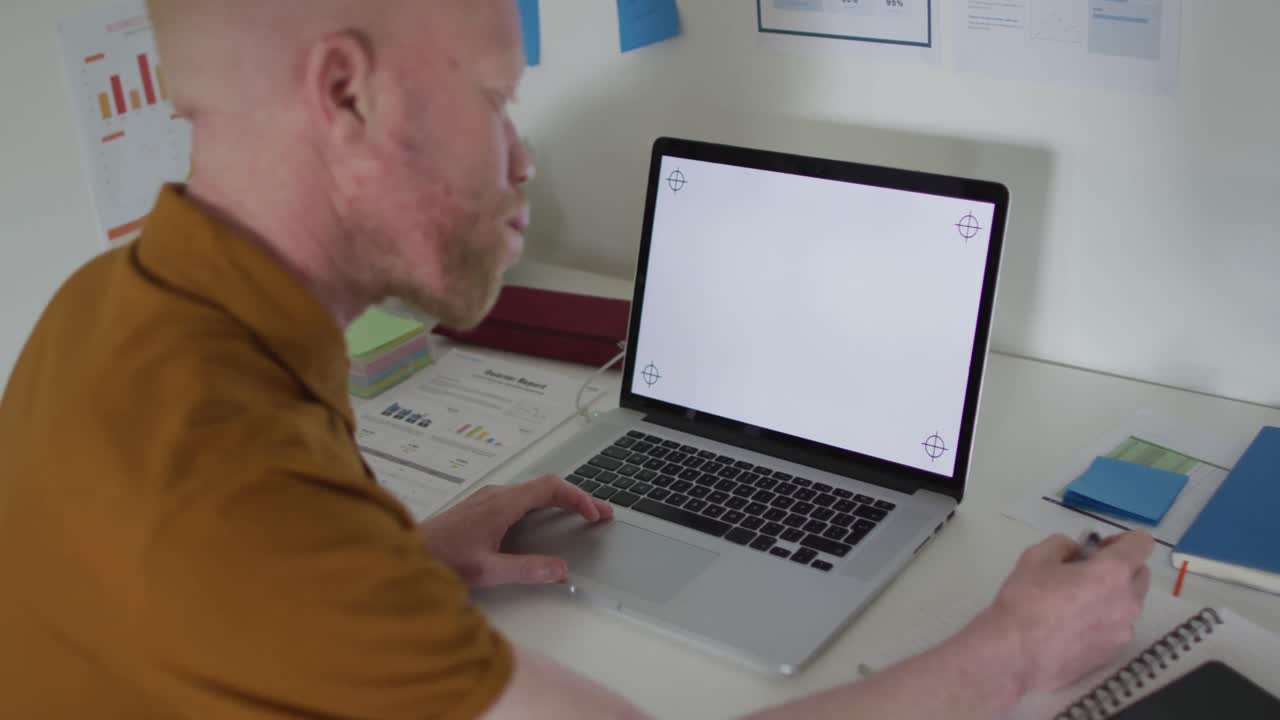hombre albino afroamericano con rastas haciendo una videollamada en la computadora portátil