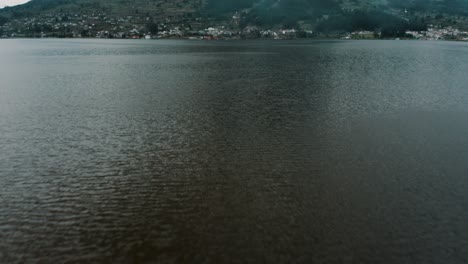 Peaceful-San-Pablo-Lake-With-Indigenous-Townscape-At-The-Foothills-Of-Inactive-Imbabura-Volcano-In-Otavalo,-Ecuador