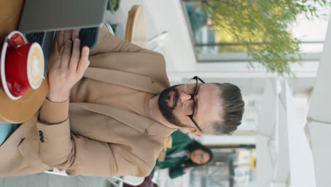 Hombre-De-Negocios-Caucásico-Que-Usa-Un-Teléfono-Inteligente-En-Un-Café-Al-Aire-Libre