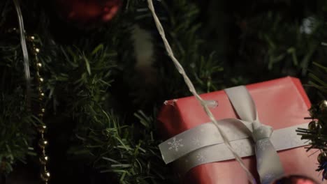 christmas tree decorated with lights baubles and gift tilting shot