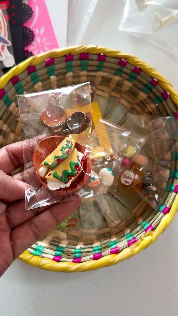 Small colorful taco figurines in cellophane paper, clay miniatures
