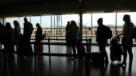 Silhouette-Der-Passagiere,-Die-Am-Flughafen-Anstehen