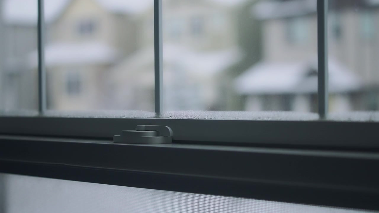 Snow falling in the suburban neighborhood outside the window in winter