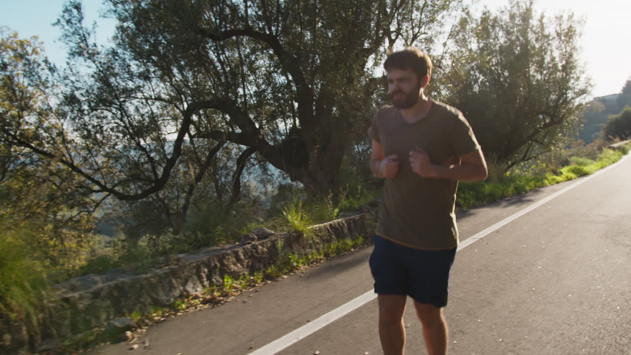 Athlete Trains By Walking Along The Country Road Under The Sun