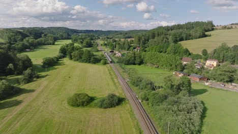 aerial view of a train on railway tracks passing through a rural landscape