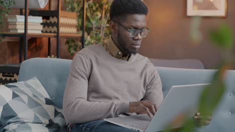 hombre trabajando en una computadora portátil en casa