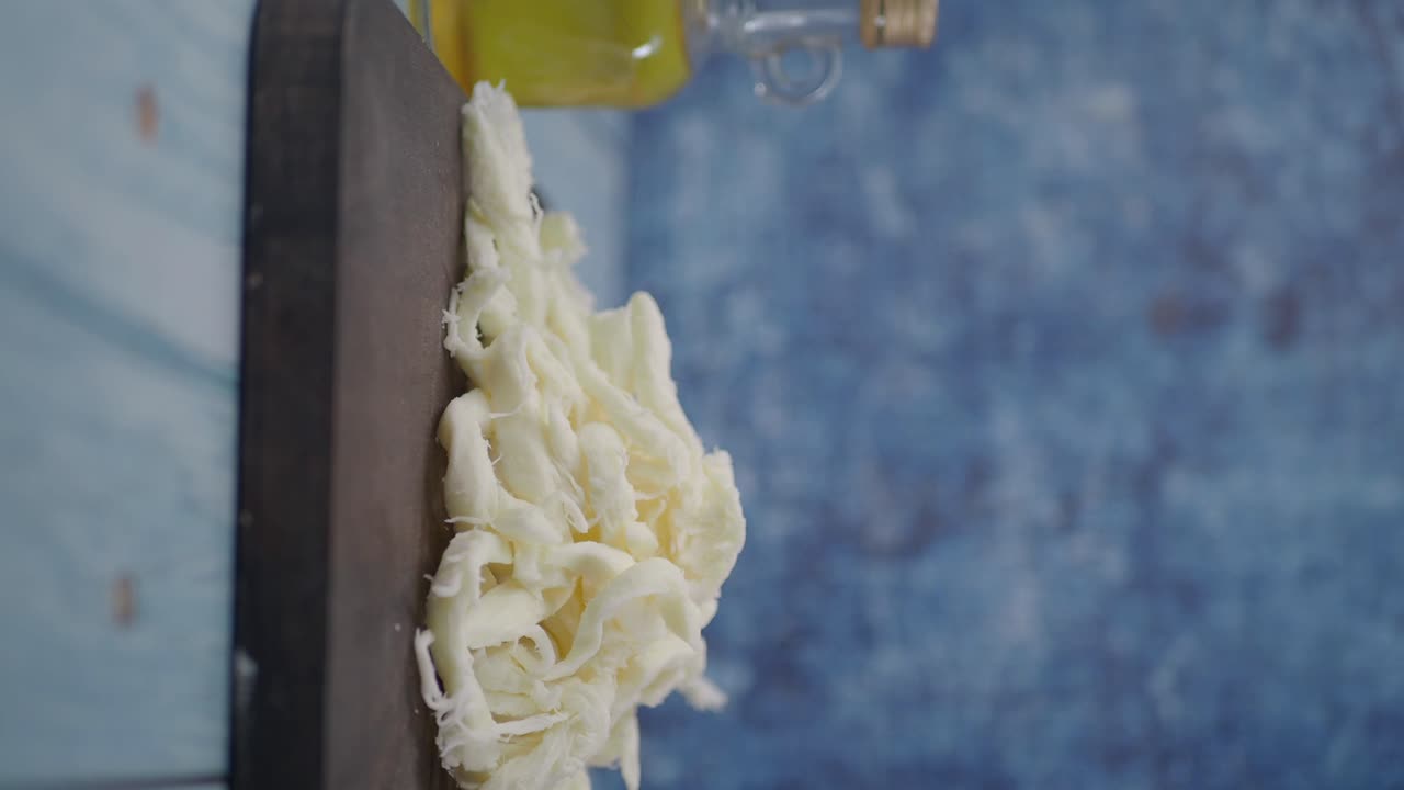 Shredded Mozzarella Cheese on Cutting Board with Olive Oil