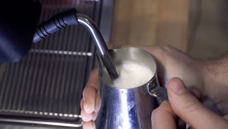 Barista-steaming-milk-with-espresso-machine-for-latte-or-cappuccino