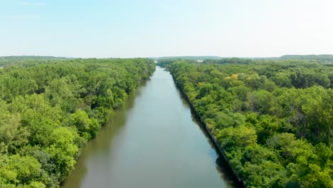 aerial drone toward a horizon over shipping canal and blue sky 4k