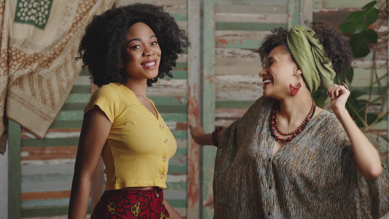 dos elegantes damas afroamericanas bailando juntas, disfrutando de música dinámica en un interior rústico, en cámara lenta