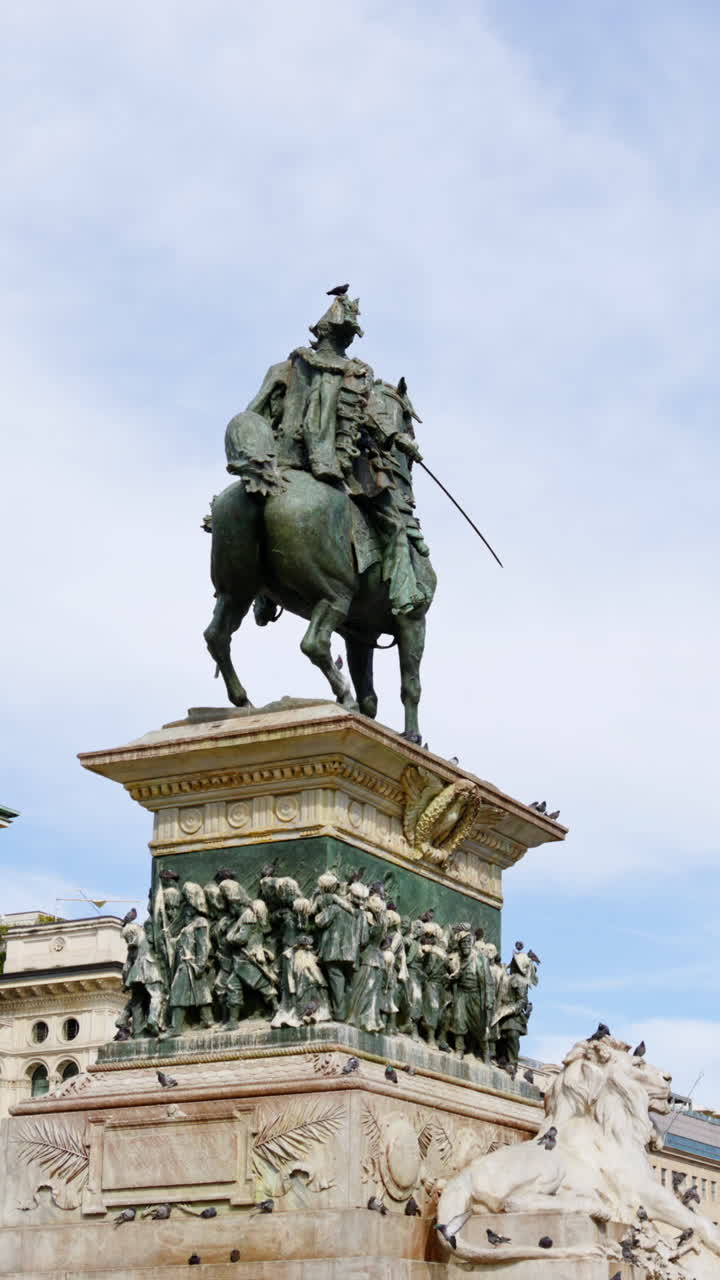 A estátua de Vittorio Emanuele II na Piazza del Duomo com a galeria e a catedral ao fundo durante o dia. Vertical