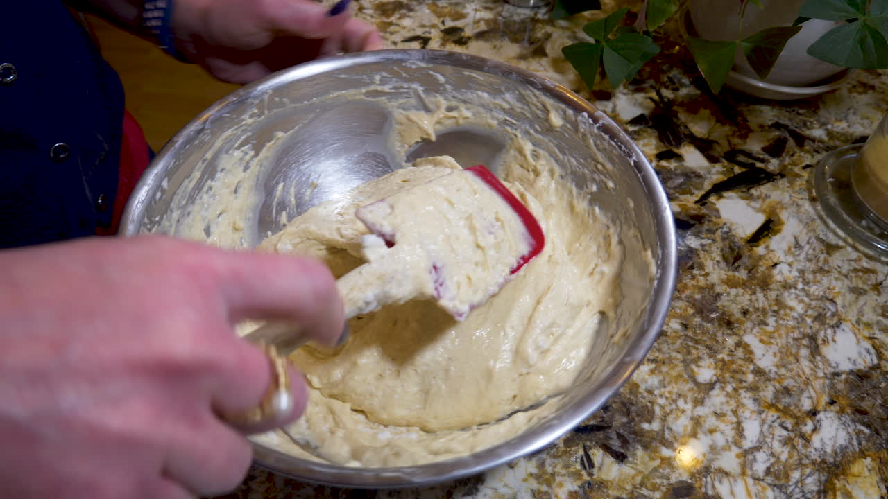 una mujer se pliega en claras de huevo batidas en masa - cerrar